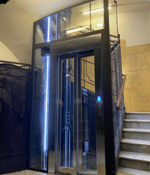 Ascensor antiguo modernizado con estructura acristalada en una comunidad de propietarios
